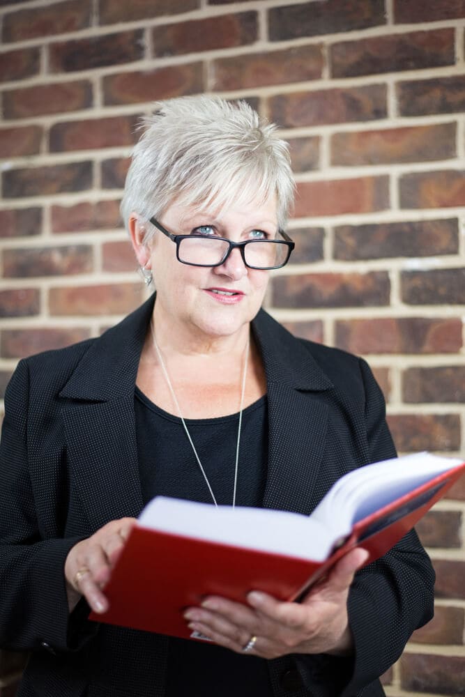 Jayne holding a big red book.