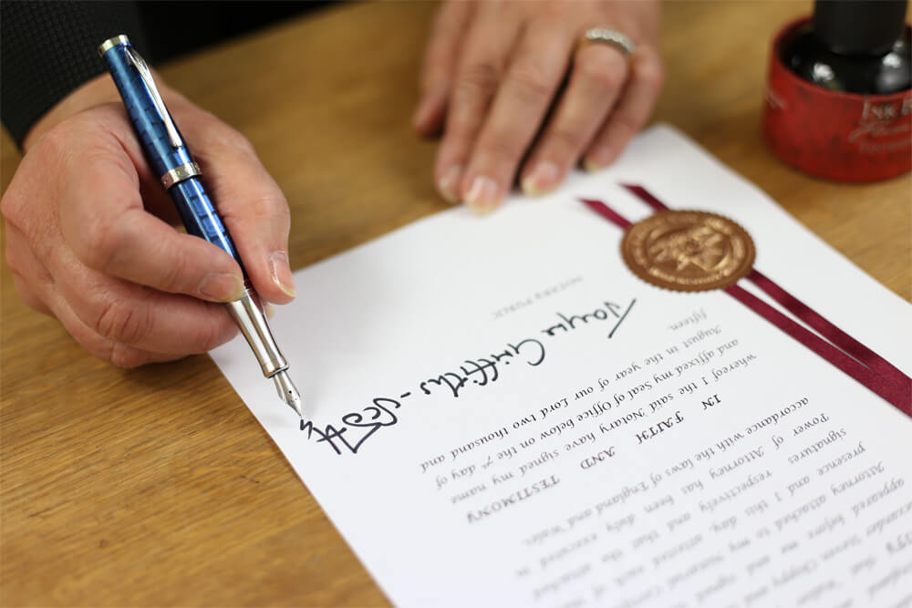 Jayne signing a document.